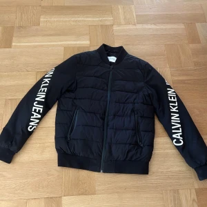 Calvin klein jacka - En Calvin klein jacka, passar till höst och vinter. Stilren. Inte använd mycket alls då jag växte ut den ganska snabbt. Inga skador på jackan, fläckar osv.