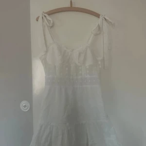 Vit klänning med fina detaljer - Mycket bra skick, blixlås på baksidan. Knytdetalj på axlarna😍