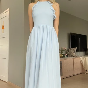 Ljusblå långklänning  - Ljusblå långklänning med volanger vid bysten. Säljer eftersom den är för kort, då jag är 180 cm. Hör gärna av dig om du vill ha fler bilder eller har frågor💞