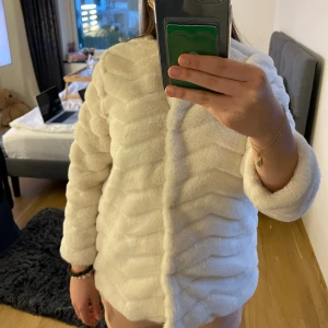 Vit pälsjacka mango - Vit pälsjacka från mango. Storlek 152 (barnstorlek) men skulle säga att den passar en XS men den blir lite kort i armarna, men det är snyggt ändå. En knapp är lite trasig som man ser i sista bilden. Tryck gärna på Köp Nu knappen!
