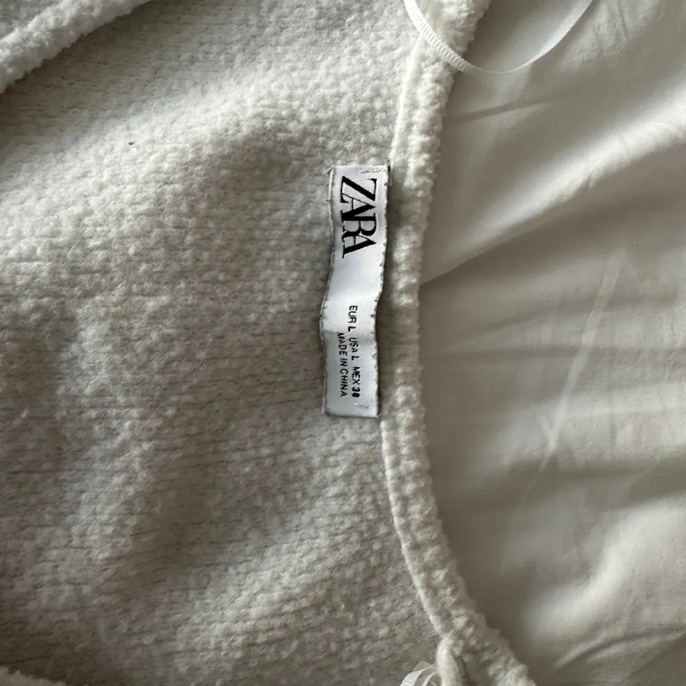 En vit stickad tröja som är väldigt liten i storleken, därav att jag köpte L(hade zs-s egentligen när jag köpte den). Använd därav priset. Den är även fin att ha bakomfram så v-ringningen är där bak.. Tröjor & Koftor.