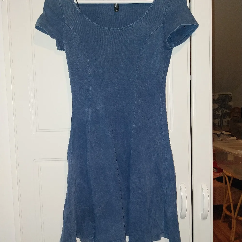 Säljer en blå klänning som ser ut att vara i jeans, men materialet är i bomull/polyester. Klänningar.