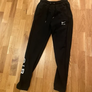 Nike Air Byxor  - Svarta Nike Air byxor Bakficka med dragkedja Fint skick( lite använd) men med 1 litet hål i vid fickan Storlek Xs  