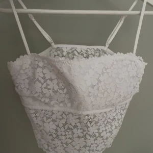 Vit topp - Söt topp med blommig spets. Har vaddering. Fint skick. Storlek 38 men mer som XS. Använd gärna ”köp nu”🫶