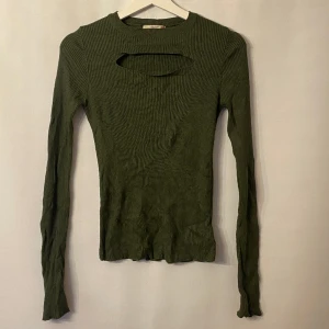 Grön topp - Grön topp med cutout vid bröstet. Märke: Dilvin. Storlek: S