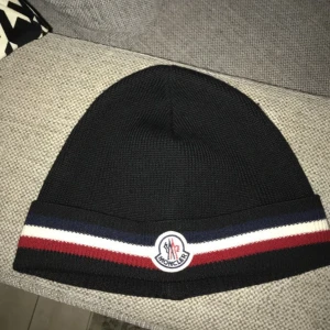 Moncler mössa - Moncler tricolour wool beanie inköpt förra vintern. Ny kostar 2225kr. Minimalt slitage, autentisk. Hör av er vid intresse och frågor! 