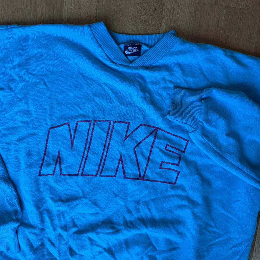 Vintage Nike tröja, i fint vintage skick = mindre defekter finns, men inget märkbart! Svårt att få med färgen på bild men den är ljusblå med rosa tryck! :). Tröjor & Koftor.