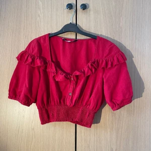Röd blus ZARA - Röd blus från Zara, fina volanger och träknappar, har en blå färg rand men syns knappt, syns på sista bilden💕