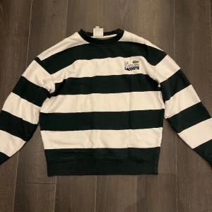 Lacoste – Randig Sweatshirt i oversize - La Chemise Lacoste - i storlek S. Passar perfekt som M då den är oversized. Bra skick, använt 1 gång. Ligger på 1700kr på Asos(nu slutsåld). Pris kan diskuteras, tveka ej med att ställa frågor!