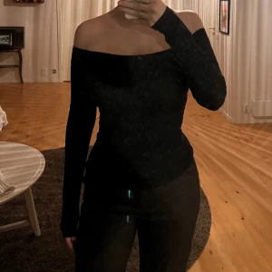 Off shoulder tröja.  - En svart offshoulder tröja som är en tunn tröja 