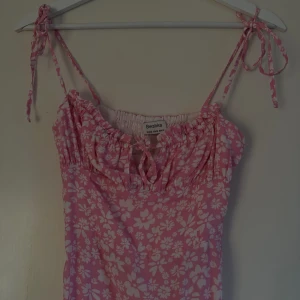 Rosa klänning - Rosa blommig klänning från Bershka. Aldrig använd. 
