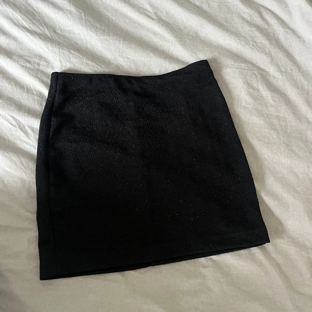 En kort svart glittrig kjol från Monki. Lätt stylad och fint material. Kjolen är i nyttskick med prislapp kvar. Den är i storlek S men passar också M eftersom att den är töjbar. Skriv om du vill ha fler bilder🥰. Kjolar.