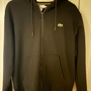 Svart lacoste hoodie använd 1-2 gånger, storlek M.