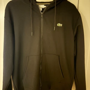 Lacoste hoodie - Svart lacoste hoodie använd 1-2 gånger, storlek M.
