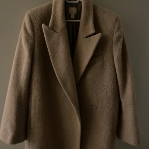 Kappa hm  - Wool blend kortare kappa från hm. I storlek S, men funkar som M också. Super fin, sparsamt använd! Beige färg.  Två knappar på framsidan. Finns ej kvar på hemsidan.