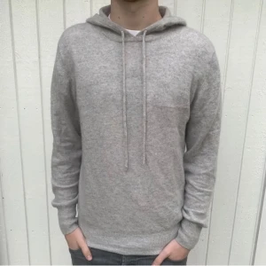 Grå kashmirhoodie från Soft Goat - Trendig 100% Kashmir hoodie från Soft Goat i väldigt bra skick. Storlek S och modellen är 178 cm. Köpt för 3000 men säljer för 1799. Sälj ej längre i denna färg! Skriv vid fler funderingar!