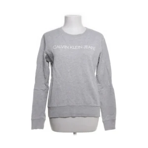 Calvin klein jeans grå tröja( äkta)   - Jättefin bra skick Calvin Klein tröja. jag använder inte den eftersom jag har en likadan. Har vanligtvis M/S men S sitter samma och passar perfekt 