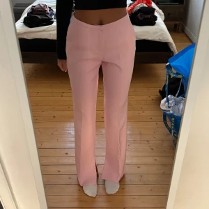 Rosa kostymbyxor  - Ett par rosa midwaist kostym byxor med slit längst ner !! Storlek 34 från Gina Tricot, modellen på byxorna heter Jane 🥰 använt en gång