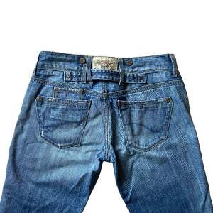 Så himla snygga lågmidjade jeans från Tommy Hilfiger! Midjemått tvärs över 40cm Innerbenslängd 72cm Passar perfekt på dig som är 165-170cm lång! Bootcut!