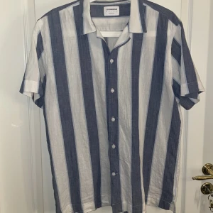 Skjorta Lindbergh - Herrskjorta från Lindbergh i storlek L (41/42) och modell relaxed fit. Perfekt till sommaren!