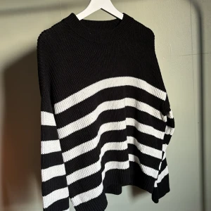 Randig stickad tröja - Stickad tröja i svart med vita ränder. Storlek L från BikBok. Sparsamt använd därav bra skick. 
