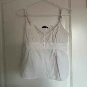 brandy melville tiffany topp - säljer denna otroligt fina topp från brandy melville eftersom den tyvärr inte sitter bra på mig. den går att justera vid axelbanden men vill ge en heads up för att urringningen är väldigt stor. sparsamt använd. onesize men XS/S.