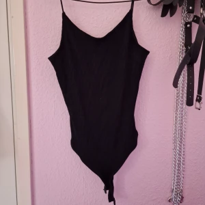 svart ribbad body - svart ribbad body i strl s med låg rygg och spagetti straps. grenen har "string" bak. endast provad! 