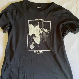 En svart T-shirt från GinaTricot med tryck! Den är i storlek S och är i fint skick!