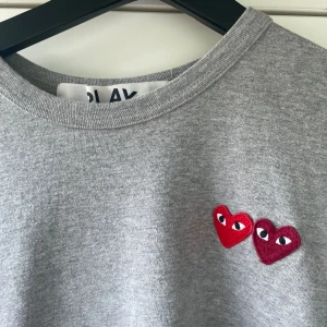 Grå t-shirt comme des Garçons - Grå T-shirt från Comme des Garçons i storlek S. Mycket bra skick. Nypris runt 800kr