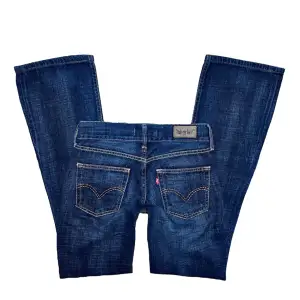 Bootcut lågmidjade utsvängda mörka levis jeans i modellen ”Eve”, i perfekt skick, kan ej skicka bild när de är på framifrån eftersom de är för små, strl XS / midja 35cm, längd 104, innerbenslängd 82cm