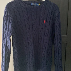 Kabelstickad Ralph lauren tröja - Säljer nu min marinblå kabelstickade Ralph lauren kofta i storlek S men är ganska stor i storleken. Den han använts ett fåtal ggr och är i väldigt bra skick! Säljer den pga av att den är lite för stor mig. Hör av dig vid frågor elr funderingar! 