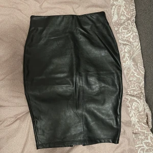 Svart kjol - Svart kjol i skinnimitation. Storlek XS, sparsamt använd. Köpt från FashionNova.