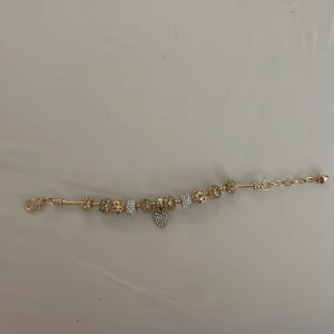 Pandora armband - Pandoraliknande armband i guld. Det är inte äkta, alltså inte från Pandora eller i äkta guld. Oanvänd 