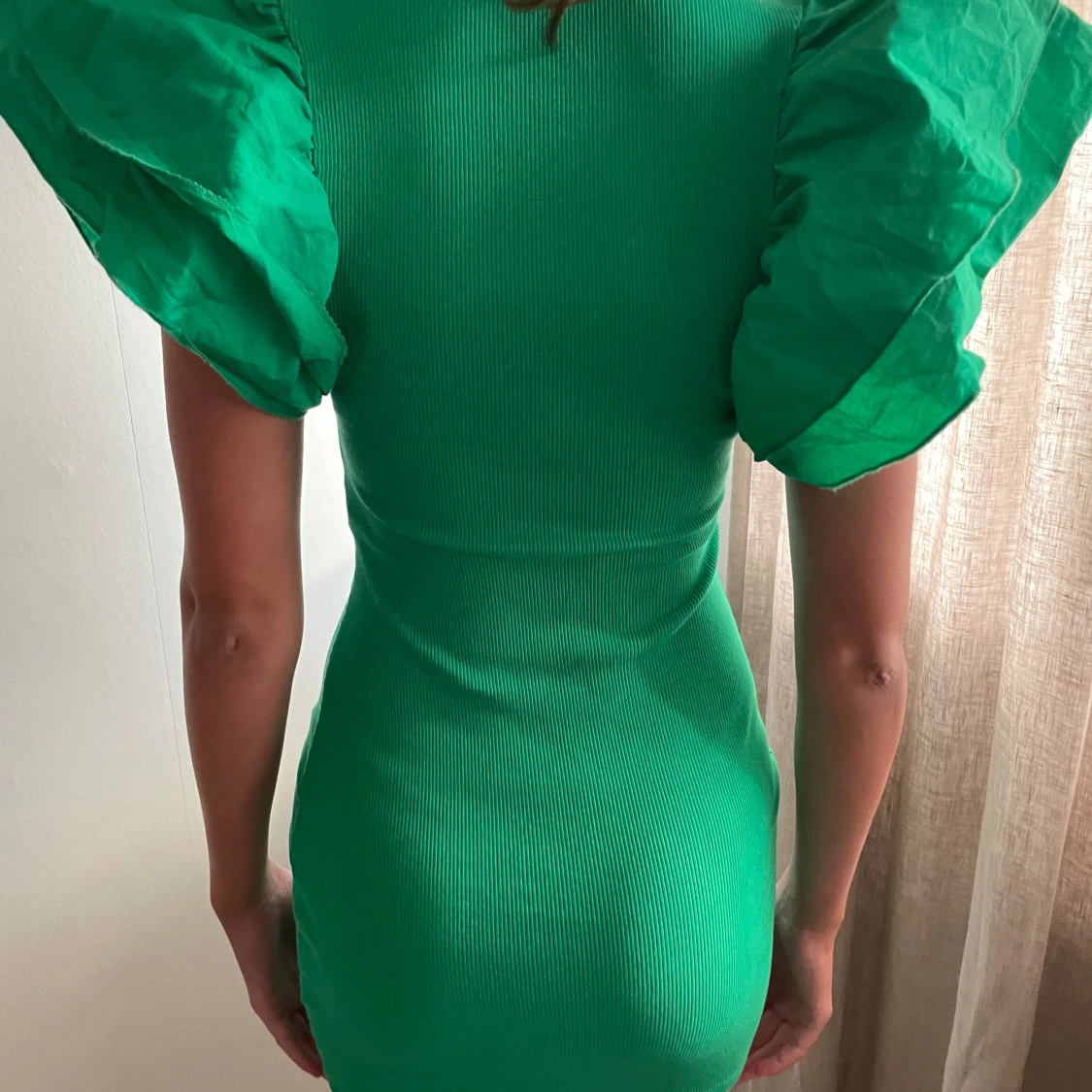 Grön kläning med piffig volang ärm