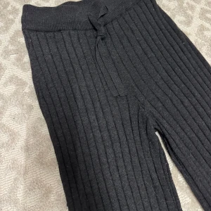 Ribbade gråa utsvängda bootcut mjukisbyxor - Ribbade supersnygga utsvängda mjukisbyxor med snören, storlek XS men passar S, de är stretchiga och supersköna. Mörkgråa/svarta typ. 