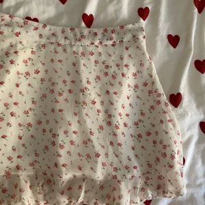 Blommig minikjol - En supersöt minikjol i blommigt mönster. Midjemåttet är 34 cm och längden är 41 cm. Perfekt nu till sommaren! 🌸