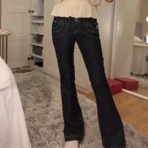 Mörkblå Lågmidjade jeans - Så unika och coola mörkblå lågmidjade jeans!! Midjemått 37 cm och innerbenslängd 80 cm. Passar xs/s