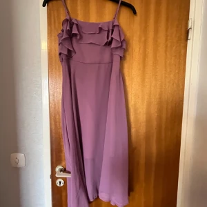  Lila sommarklänning -  Säljer denna jättefina sommarklänningen den Har en slit Den har två material den som är inne är satin den som är ute är genomskinlig skriv gärna om ni är intresserade.