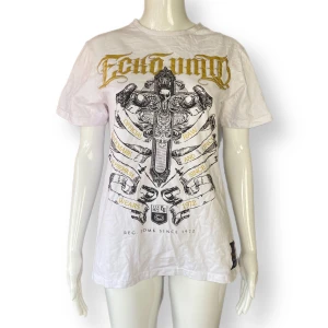 Y2K Tee - I fint skick. Behöver strykas. Från Eckō unltd. Storlek Medium. Dockan använder XS. Upplever tröjan som mindre i storlek. (Iallafall om den är menad för en man) MÅTT: Axel till axel 43cm, ärmlängd 19cm, armhåla till armhåla 49cm & längd 65cm 