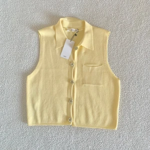 Mango ljusgul finstickad väst med strassknappar - Otroligt söt finstickad ljusgul väst från Mango med krage och strassknappar. Ny med tags kvar. Utan anmärkningar.