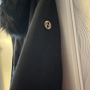 En fin lång hollis kappa  - En lång svart hollies kappa, jätte skön och snygg! 