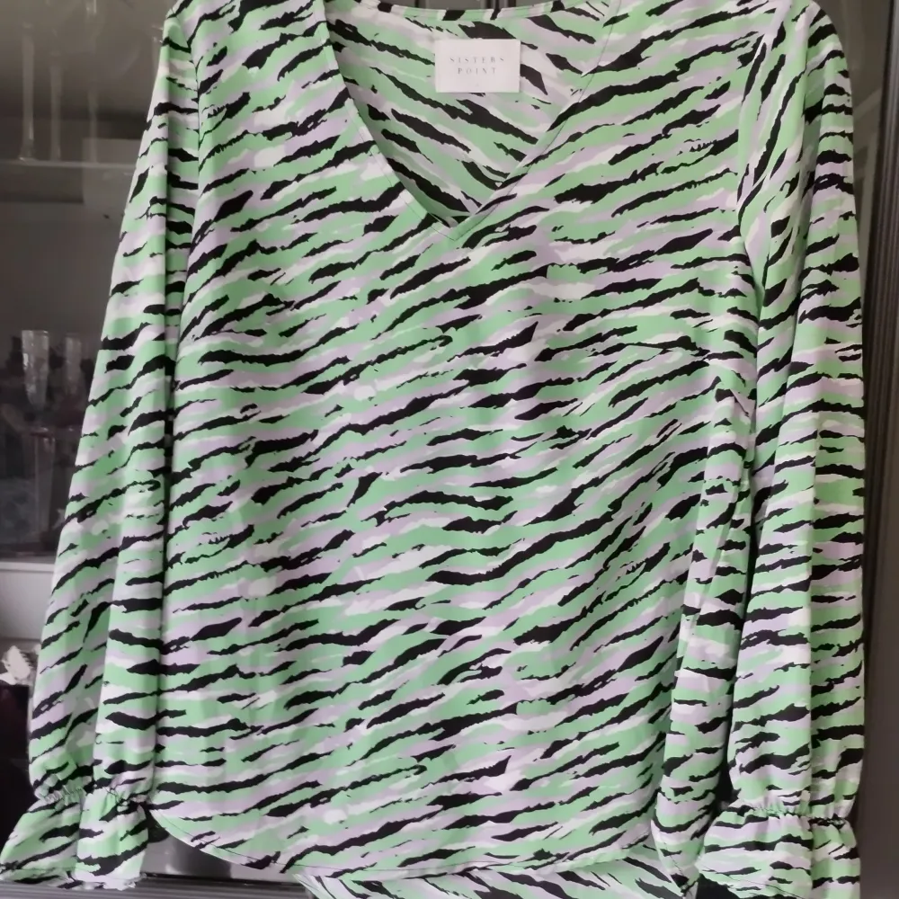 En zebra mönstrad vårig Blus med inslag av annat mintgrönt och ljuslila i färgerna. Volang längst ner i ärmen. Obetydligt använd. . Blusar.