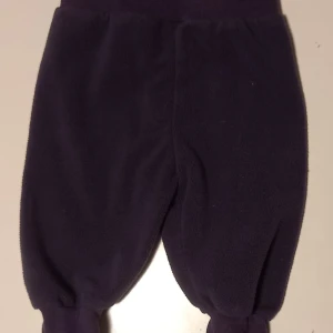 Lila fleecebyxor strl. 62 - Tunna lila fleecebyxor i storlek 62 från Hm. Nedvikbar mudd i midjan och i benen för förlängd användningstid. I fint begagnat skick, inga hål eller fläckar.  Tvättad i parfymfritt tvättmedel och utan sköljmedel.