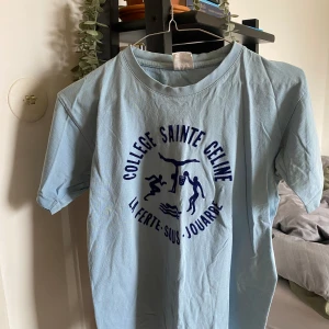 Tshirt  - T-shirt med tryck. Oklar storlek men troligtvis M.