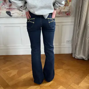 Lågmidjade bootcut jeans, nitdetaljer Midjemått 78cm Innerbenslängd 78cm