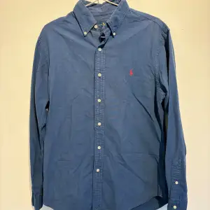 Ralph Lauren skjorta, Mörkblå med röd Badge. Storlek M Skick 9/10