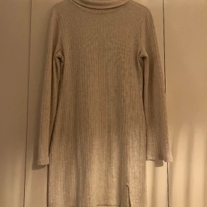 Vinter klänning  - Fin vinter klänning med halv polo. Använd en gång. Slutar lite ovanför knäna med en lite slits på sidan.