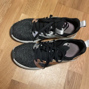 Gympaskor (sketchers)  - Ett par svarta sketchers med roseguld och silver detalj, använt skick. Har ändå mycket kvar att ge. 