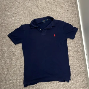 Polo Ralph lauren piké  - Väldigt stilig polo piké som kommer att vara perfekt nu när sommaren är runt hörnet. Det är en slim  fit tröja som är i storlek 10-12.  