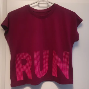 Snygg sportig croptop - Mörk ceriserosa sporttopp i croptop stuk. Med ordet "Run". I mkt bra skick 